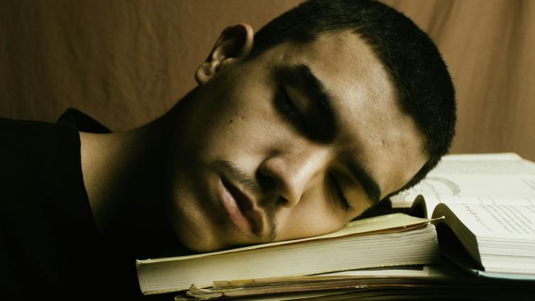 Person sleeping on a stack of books